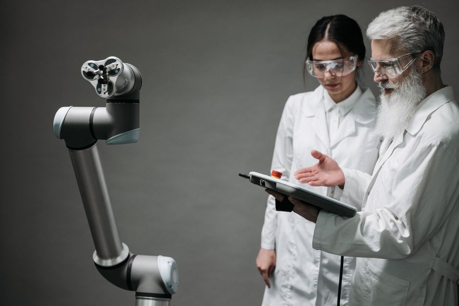 Znanstvenici u laboratorijskim kutama analiziraju robotsku ruku